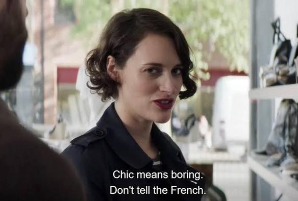 A woman, "Fleabag," with short, curly hair smirks while wearing a dark jacket. She is in a shoe store. The caption reads "Chic is boring. Don't tell the French."