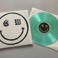 Ein Albumcover mit einem Smiley mit den Buchstaben "GW" und einer türkisfarbenen Schallplatte daneben.