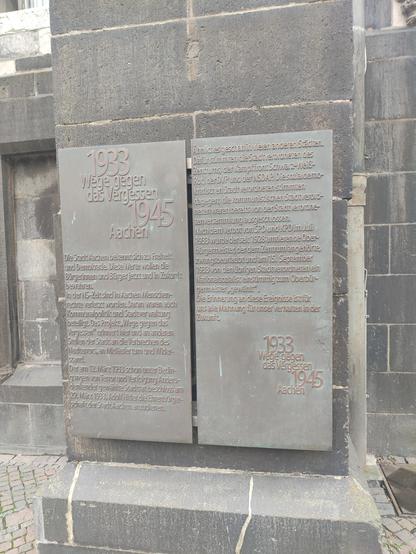 "Die Stadt Aachen bekennt sich zu Freiheit und Demokratie. Diese Werte wollen die Bürgerinnen und Bürger jetzt und in Zukunft bewahren.
In der NS-Zeit sind in Aachen Menschenrechte verletzt worden. Daran waren auch Kommunalpolitik und Stadtverwaltung beteiligt. Das Projekt „Wege gegen das Vergessen“ erinnert hier und an anderen Stellen der Stadt an die Verbrechen des Naziterrors, an Mitläufertum und Widerstand.
Der am 12. März 1933 schon unter Bedingungen von Terror und Verfolgung Andersdenkender gewählte Stadtrat beschloss am 29. März 1933, Adolf Hitler die Ehrenbürgerschaft der Stadt Aachen anzudienen.
Ähnliches geschah in vielen anderen Städten. Dafür stimmten die Stadtverordneten des Zentrums, der Kampffront Schwarz-Weiß-Rot, der DVP und der NSDAP. Die sozialdemokratischen Stadtverordneten stimmten dagegen; die kommunistischen Stadtverordneten waren bereits von der Stadtverordnetenversammlung ausgeschlossen.
Nach dem Verbot von SPD und KPD im Juli 1933 wurde der seit 1928 amtierende Oberbürgermeister, der dem Zentrum angehörte, zwangsbeurlaubt und am 15. September 1933 von den übrigen Stadtverordneten ein Nationalsozialist einstimmig zum Oberbürgermeister gewählt.
Die Erinnerung an diese Ereignisse ist für uns alle Mahnung für unser Verhalten in der Zukunft."