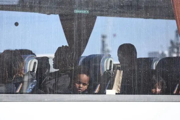 Des migrants, dont de jeunes enfants, interceptés en mer alors qu’ils tentaient de traverser la Manche depuis la France, quittent le centre des forces frontalières à bord d’un autocar à Douvres, dans le sud-est de l’Angleterre, le 19 septembre 2025. 
