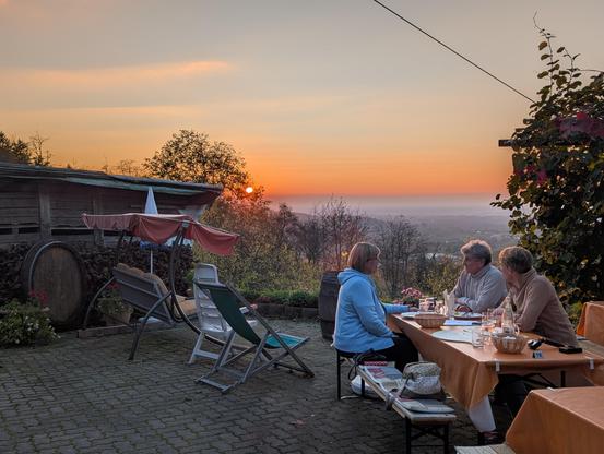 Wir sitzen auf der Weinterasse mit anderen Gästen und genießen dem Abend