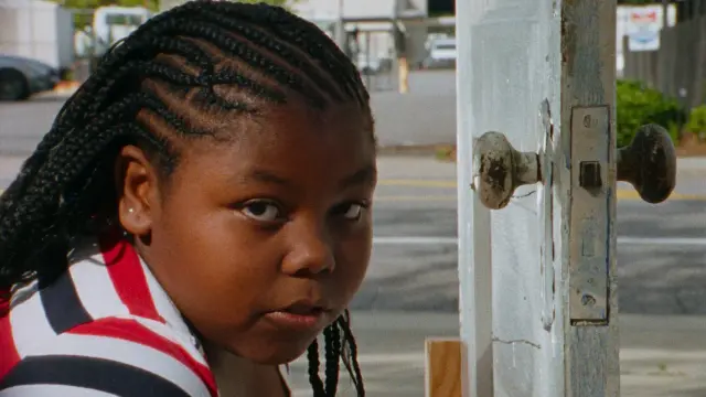 still of the documentary film "The Magic City - Birmingham According to Sun Ra" by Guillaume Maupin & Pablo Guarise - close up of the face of young afroamerican girl looking into the camera