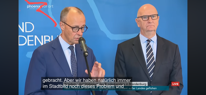 F. Merz (l.) und Dietmar Woidke bei einer Pressekonferenz. Merz sagt (verteilt auf 4 Screenshots mit UNTERTITELN):

„Und bei der Migration sind
wir sehr weit. Wir haben in dieser Bundesregierung die Zahlen August 24, August 25 um 60% nach unten gedrückt. Aber wir haben natürlich immer im Stadtbild noch dieses Problem. Und deshalb ist der Bundesinnenminister ja jetzt dabei, in großem Umfang auch Rückführungen zu organisieren und durchzuführen“