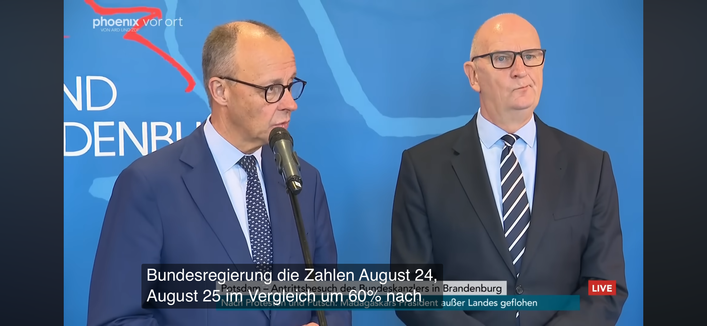 F. Merz (l.) und Dietmar Woidke bei einer Pressekonferenz. Merz sagt (verteilt auf 4 Screenshots mit UNTERTITELN):

„Und bei der Migration sind
wir sehr weit. Wir haben in dieser Bundesregierung die Zahlen August 24, August 25 um 60% nach unten gedrückt. Aber wir haben natürlich immer im Stadtbild noch dieses Problem. Und deshalb ist der Bundesinnenminister ja jetzt dabei, in großem Umfang auch Rückführungen zu organisieren und durchzuführen“