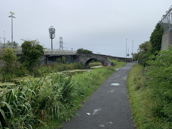 Die schiefe, kleine, graue Steinbrücke führt über einen Kanal