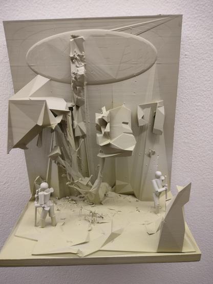 Abstrakcyjna rzeźba w odcieniach beżu przedstawiająca dwóch małych, stylizowanych ludzików w futurystycznym krajobrazie z geometrycznymi, kanciastymi formami. W centrum kompozycji znajduje się duża struktura przypominająca drzewo lub kolumnę, nad którą unosi się owalny, dyskowaty kształt. Całość ma charakter surrealistyczny i przypomina scenę eksploracji obcej planety.