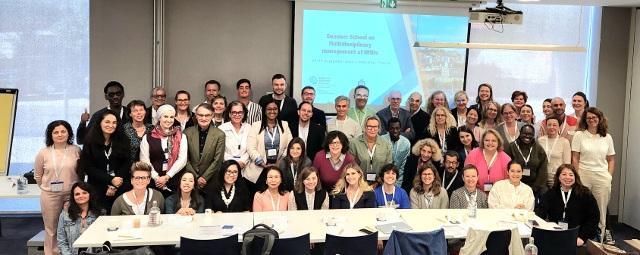 Photo de groupe des participants et intervenants de la Summer School 2025 sur les maladies neuromusculaires, réunis devant un écran de présentation dans une salle de conférence à Marseille.