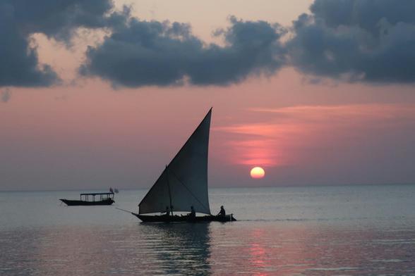 A traditional dhow sailing the calm waters of Nungwi as the sun begins to set — pure Zanzibar magic.