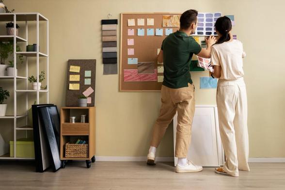 Two people discussing interior design boards in a modern office