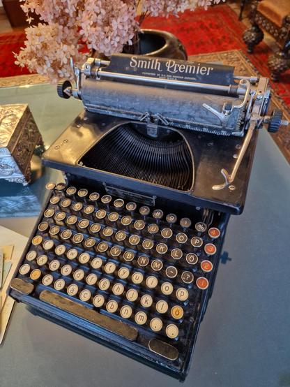 Old Smith Premier typewriter with circular keys. The top row are digits, then there's three rows of the usual QWERTY capital letter keys, but also a second set of three rows of qwerty keys with small letters.