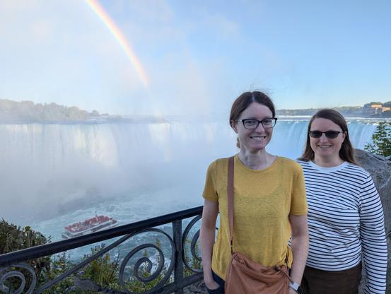 My sister and me at Niagara Falls with the horseshoe falls behind us and a rainbow