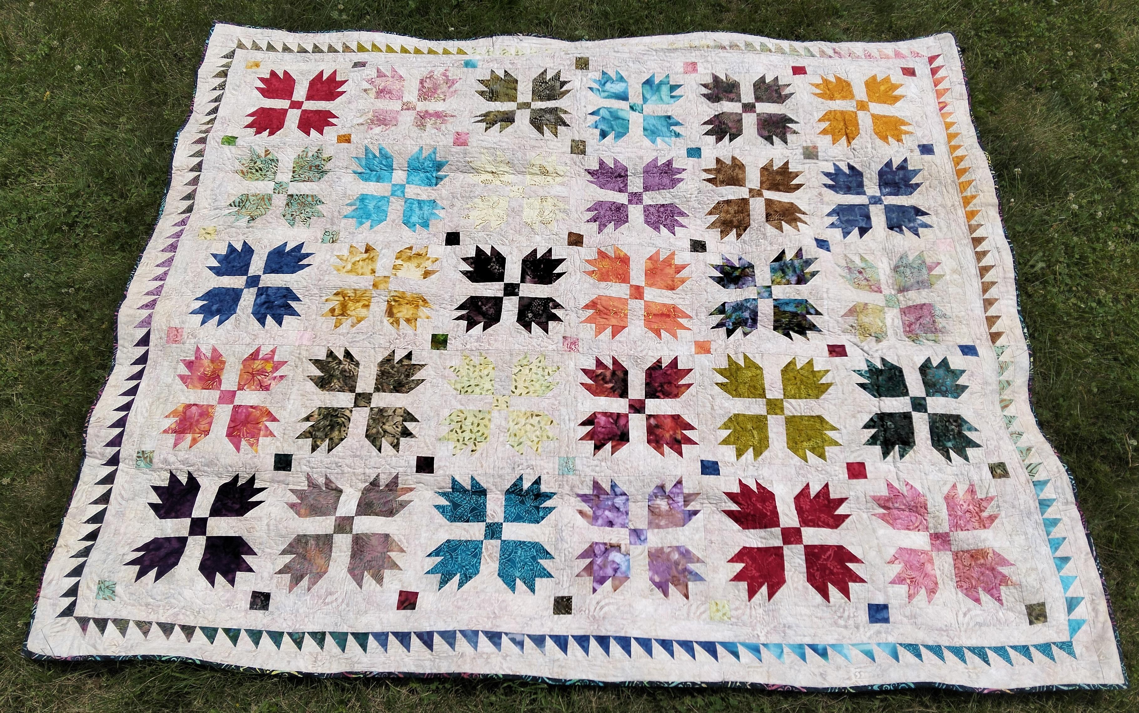 71 x 83.5 (180 x 212 cm), it is bear paw designs in many windows, bright colors, against a light background, a border of thing triangles in a row