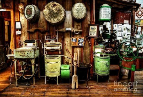 I captured this image in an old museum on mid north coast, NSW, Australia.

Clothes washer technology developed as a way to reduce the manual labor spent, providing an open basin or sealed container with paddles or fingers to automatically agitate the clothing. The earliest machines were hand-operated and constructed from wood, while later machines made of metal permitted a fire to burn below the washtub, keeping the water warm throughout the day's washing.

The earliest special-purpose washing device was the scrub board, invented in 1797.

By the mid-1850s, steam-driven commercial laundry machinery was on sale in the UK and US. Technological advances in machinery for commercial and institutional washers proceeded faster than domestic washer design for several decades, especially in the UK. In the US there was more emphasis on developing machines for washing at home, though machines for commercial laundry services were widely used in the late 19th and early 20th centuries. The rotary washing machine was patented by Hamilton Smith in 1858. As electricity was not commonly available until at least 1930, some early washing machines were operated by a low-speed single-cylinder hit and miss gasoline engine.

After the items were washed and rinsed, water had to be removed by twisting. To help reduce this labor, the wringer/mangle machine was developed.

