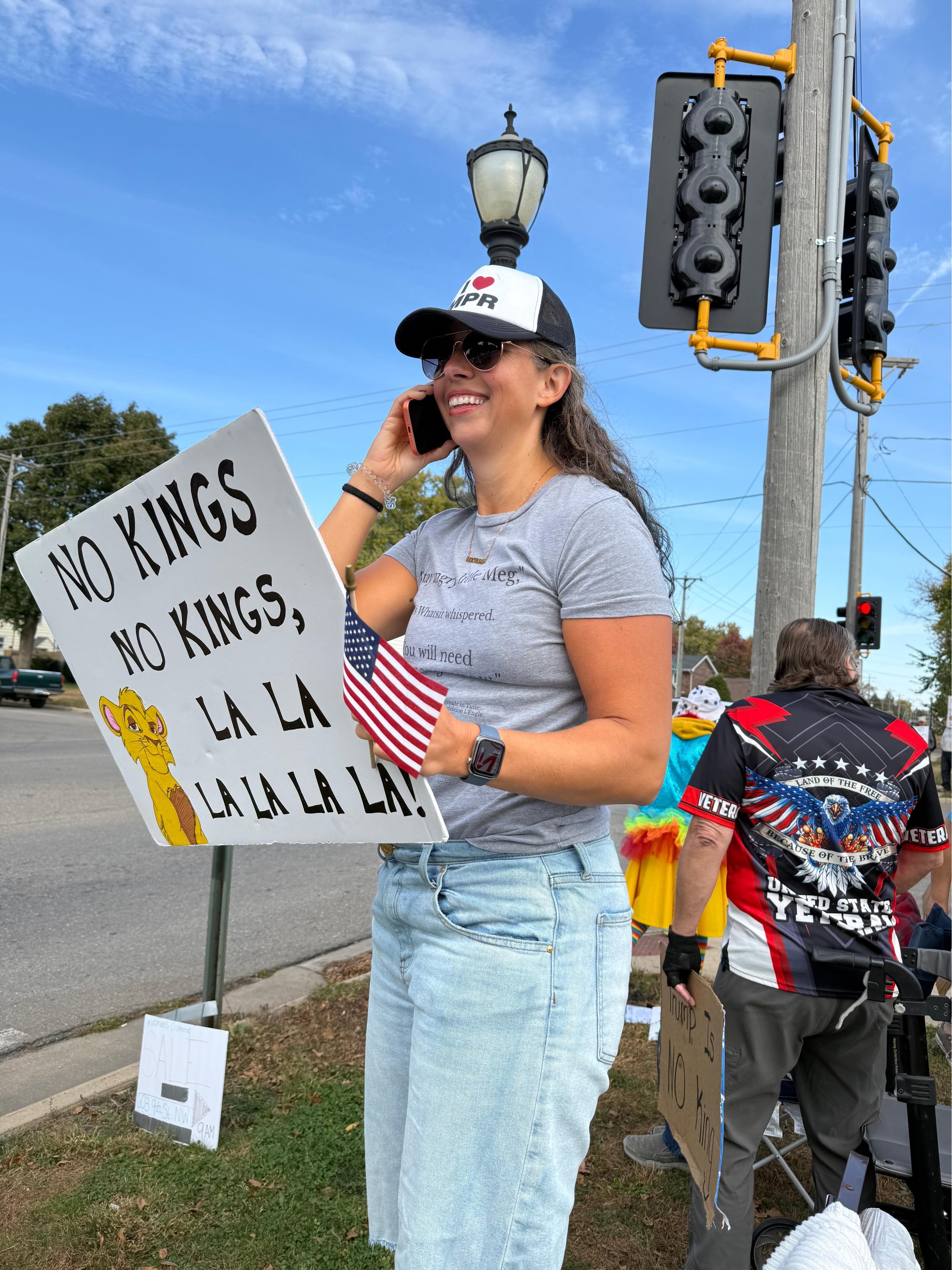 I’m talking on my orange iPhone holding a sign with Simba on it that says “no kings no kings la la la la la la”