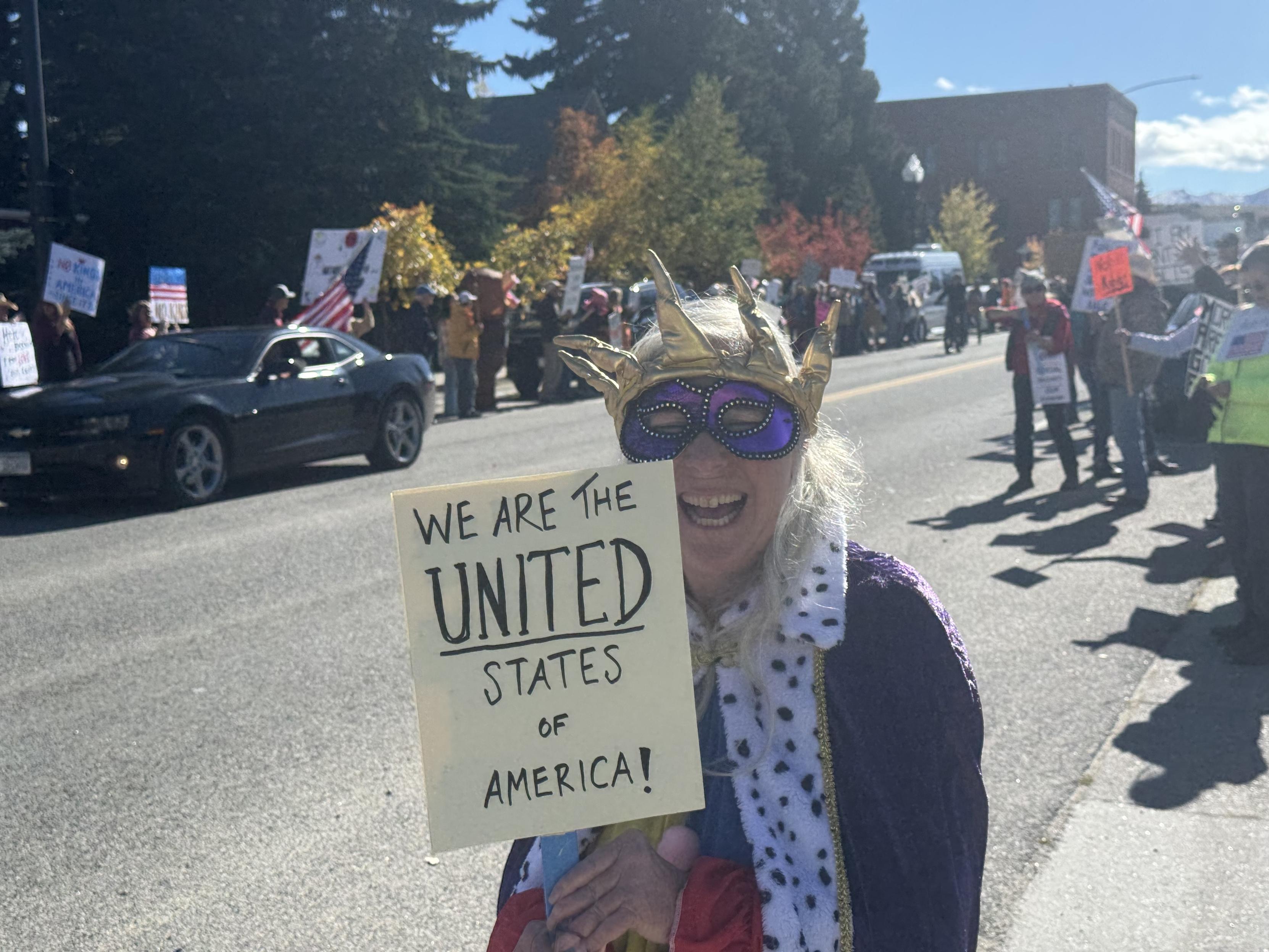 A protester wearing a crown and ermine robe at the no kings protest