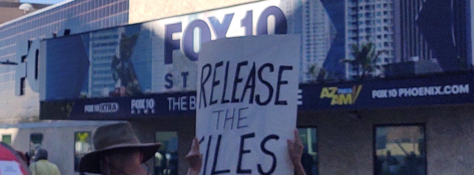 A "Release the Files" poster in front of the offices for a Fox affiliate office