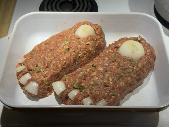 Two loaves of meat shaped to look like severed feet with onions for ankle bones and toenails.