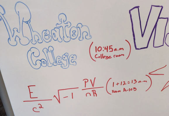 Whiteboard with the names of various colleges rendered prettily, and one is a big formula-looking thing that I won't bore you with because you know it's going to spell out MIT.