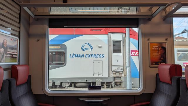 Lateral view of a train window, a SNCF Régiolis with Léman Express logo visible