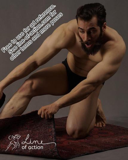 Model Sadeq poses in black underwear. He is kneeling on a small carpet, holding on to the front corners as making an expression of fright and excitement. The Line of Action logo is at the bottom. Text reads free to use for art reference. See line-of-action.com for other terms and more poses.