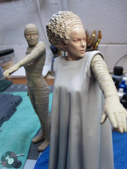 Model kit of The Bride of Frankenstein from X-Plus. Gowned Bride in front and bandaged Bride in the background. Tan bandages, white gown an flesh tones for the face.