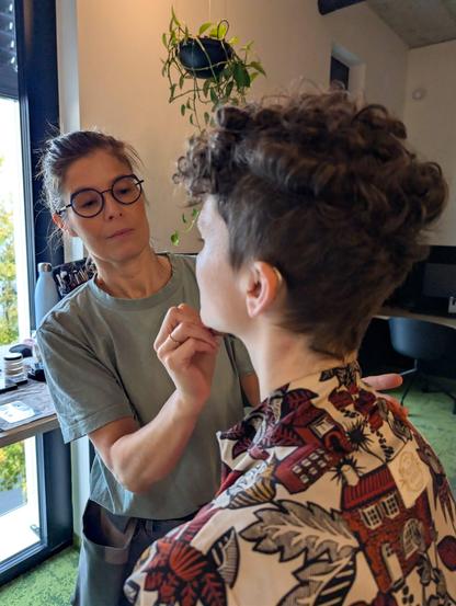 Eine Mitarbeiterin wird fürs Fotoshooting geschminkt