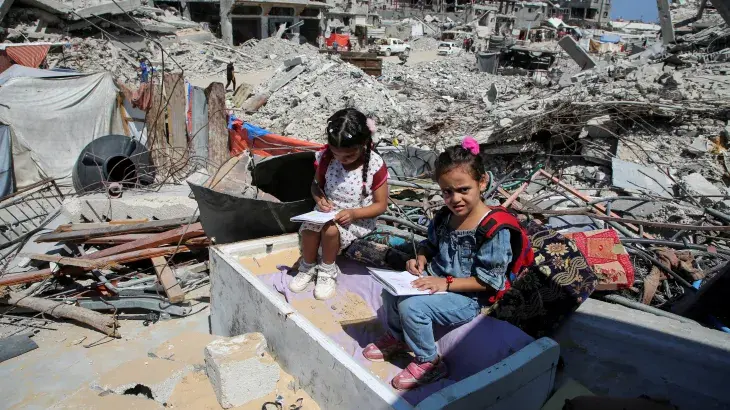 Two girls learning in the ruins.