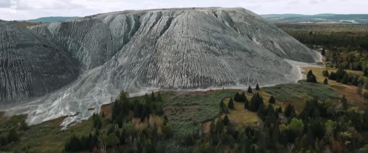 exploitation d'une mine d'amiante au canada = fibre d'amiante à l'air libre circulant jusqu'en aval via érosion, pluies et vents.