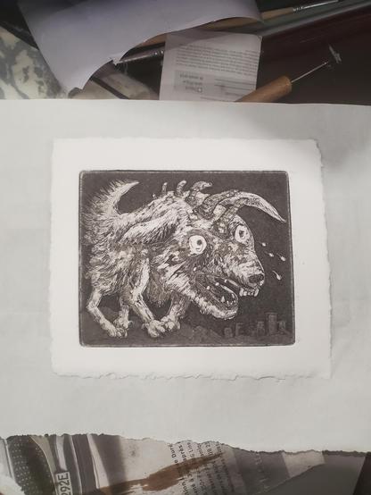 Un monstre-chien pleurniche, les yeux équarquillés et les pattes en-dedans. Il a de toutes de petites dents un peu ridicules et des cornes qui lui sortent le long de la colonne vertébrale. Des immeubles au loin.