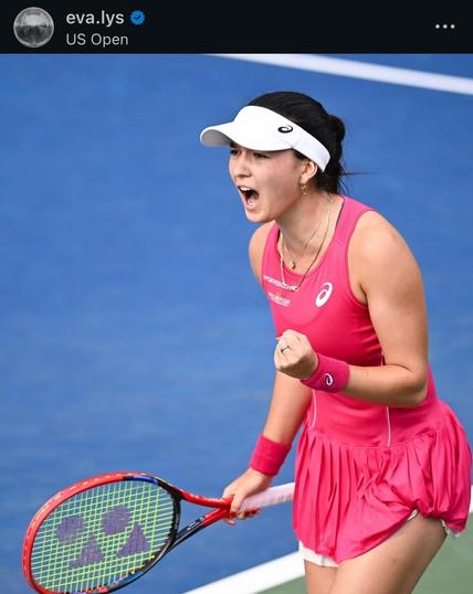 Tennisspielerin Eva Lys in einem leuchtend rosa Kleid feiert einen Punkt während eines Spiels bei den US Open und zeigt Aufregung mit geballter linker Faust und einem Tennisschläger in der rechten Hand.