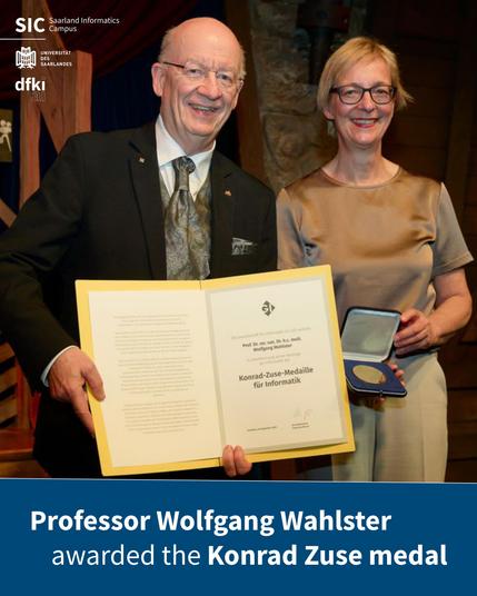 Prof. Dr. Dr. h.c. mult. Wolfgang Wahlster holding his award certificate. Next to him stands a woman holding out his medal.