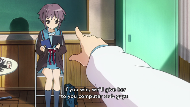 The hand of a girl (Haruhi) pointing at a girl (Nagato) sitting in a chair looking at a CD case in one hand while holding a book in the other. A subtitle says, "If you win, we'll give her to you computer club guys."