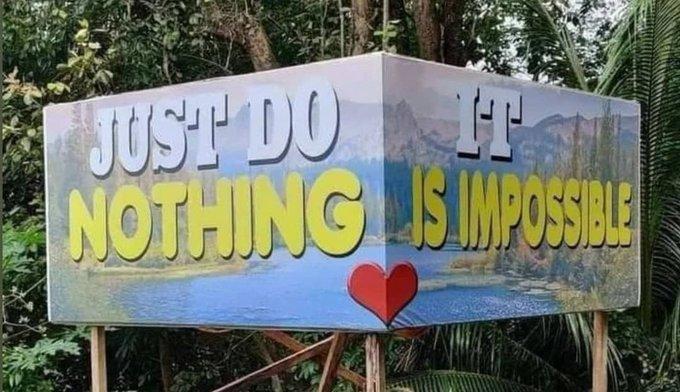 A signpost in the woods with an idyllic view of a lake, an a superimposed text that reads "Just Do It, Nothing is Impossible" or "Just Do Nothing, It Is Impossible" depending on your day.