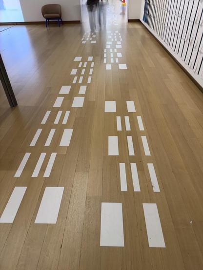 White checkered stickers on a parquet floor. In the distance, the blocks together form the number 30.