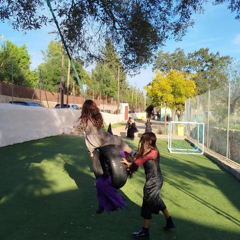 Una nina impulsa una roda que serveix de gronxador per a altres dues nines.