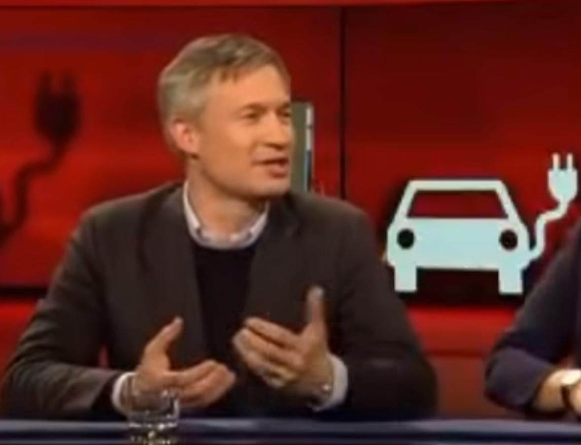 Ulf Poschardt bei “Hart aber fair”, Elektroauto-Piktogramm im Hintergrund”