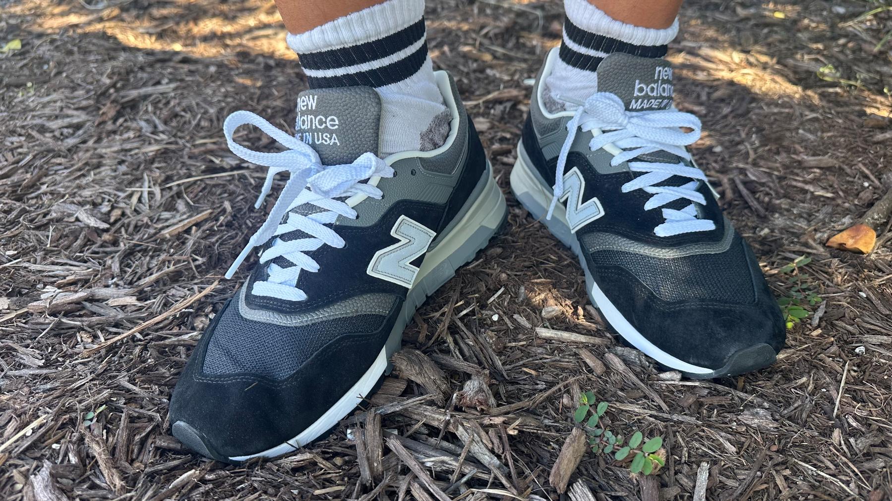 Blue and white new balance sneakers with white and blue stripe tube socks. 