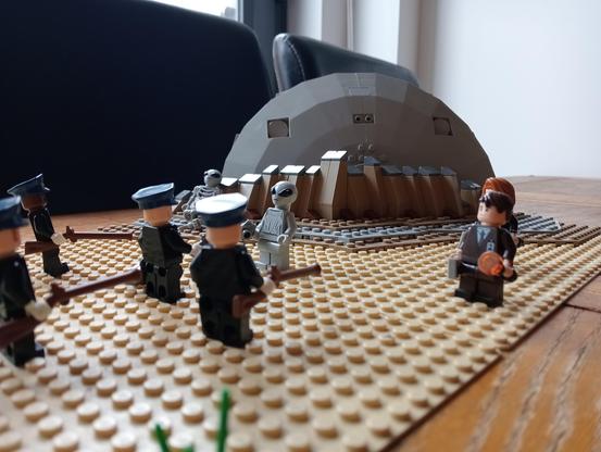 Some LEGO cops facing a UFO survivor with rifles, Mulder and Scully standing by to negotiate, crashed UFO in the background