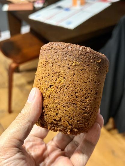 A hand holding a round mini loaf of Icelandic rye bread