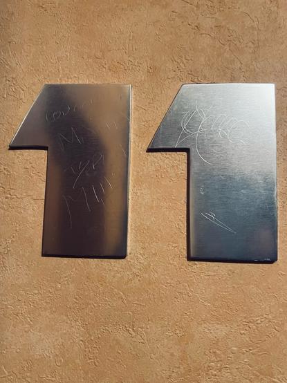 number eleven in metallic letters over a brown wall 