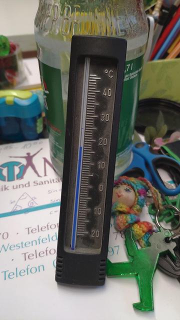 Das Bild zeigt im Vordergrund ein Thermometer. Es zeigt 17 Grad an.