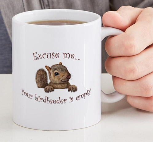 A very cute coffee/tea mug with a cute squirrel saying "Excuse me...your birdfeeder is empty"