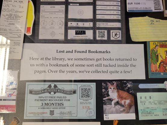 A collection of bookmarks in a glass display case. Text at center reads "Lost and Found Bookmarks
Here at the library, we sometimes get books returned to us with a bookmark of some sort still tucked inside the pages. Over the years, we've collected quite a few!"
