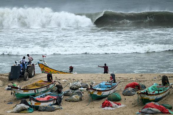 Fishing boats are pulled ashore at Marina beach ahead of Cyclone Montha, Chennai, with huge waves already forming.