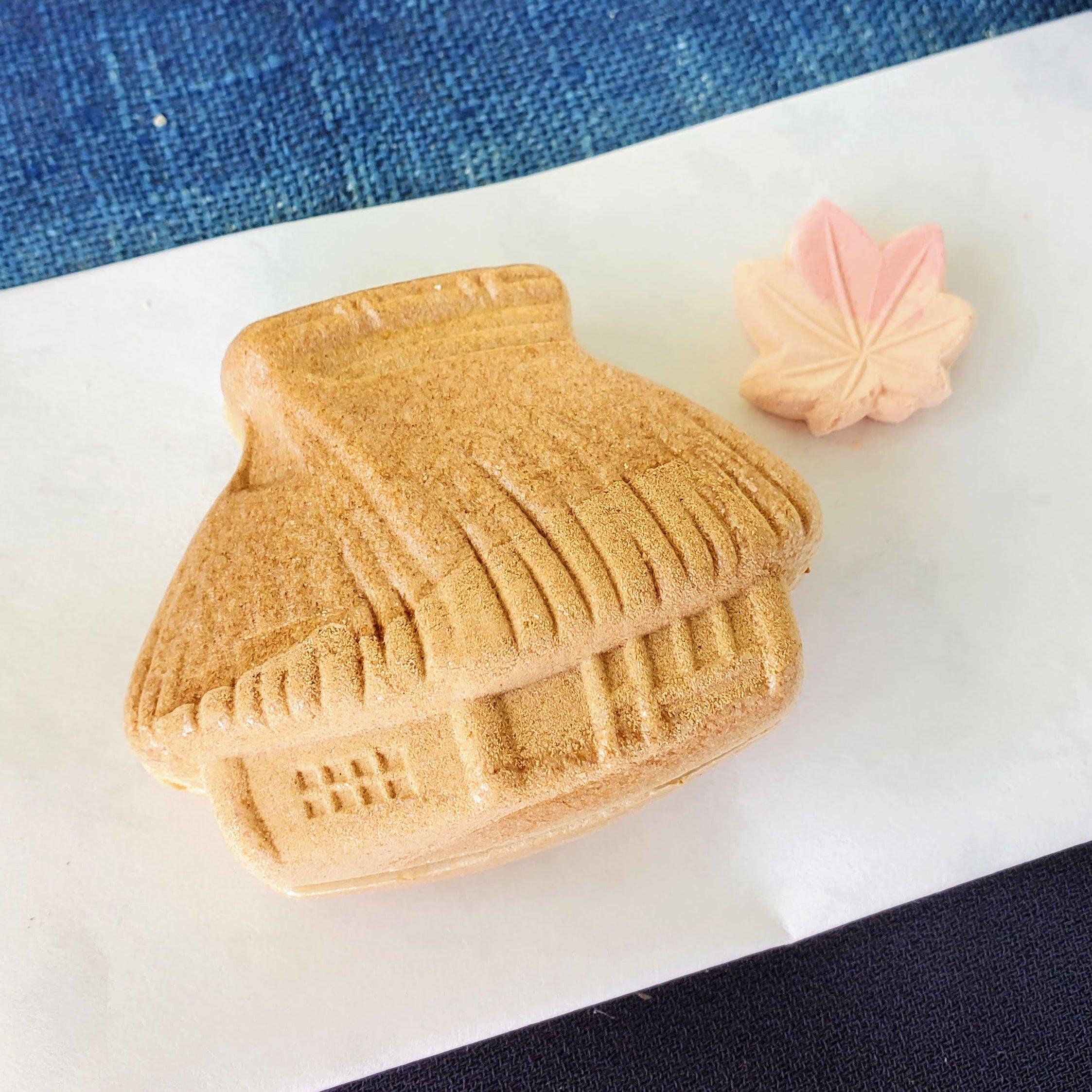 A monaka sweet in the shape of a thatched hut.