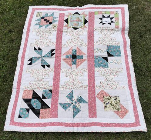 a photo of a quilt, it has 15 windows, in every other row is an image of a design done with light reds, blacks, and blues and whites, really soft and gentle looking 
