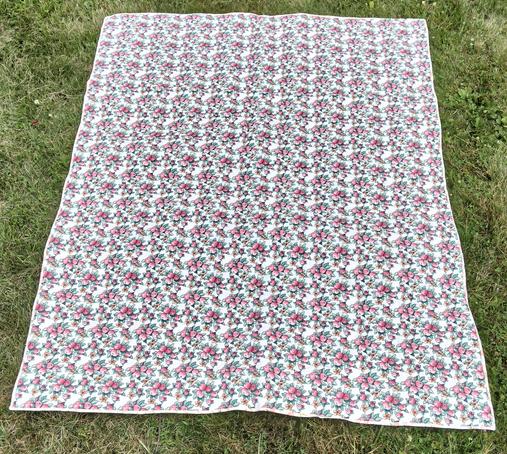 a photo of the reverse side, it is small light red and pink floral patterns on a white backing 