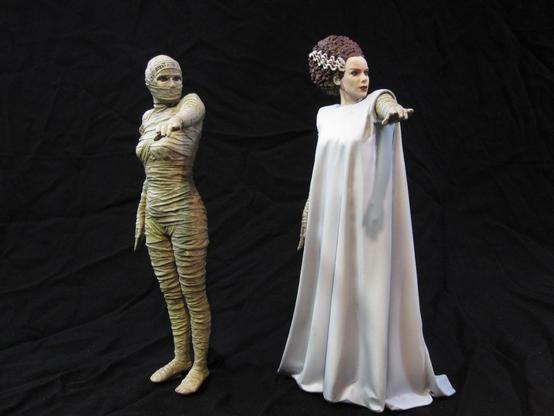 X-Plus bride of Frankenstein model kit. White gowned Bride on the right. Bandaged Bride on the left. Black background.
