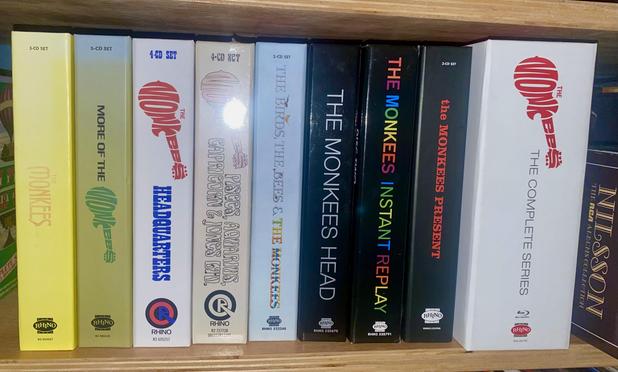 A shelf displaying various box sets of music by The Monkees, including titles like "The Monkees," "More of The Monkees," "Headquarters," "The Birds, The Bees & The Monkees,"