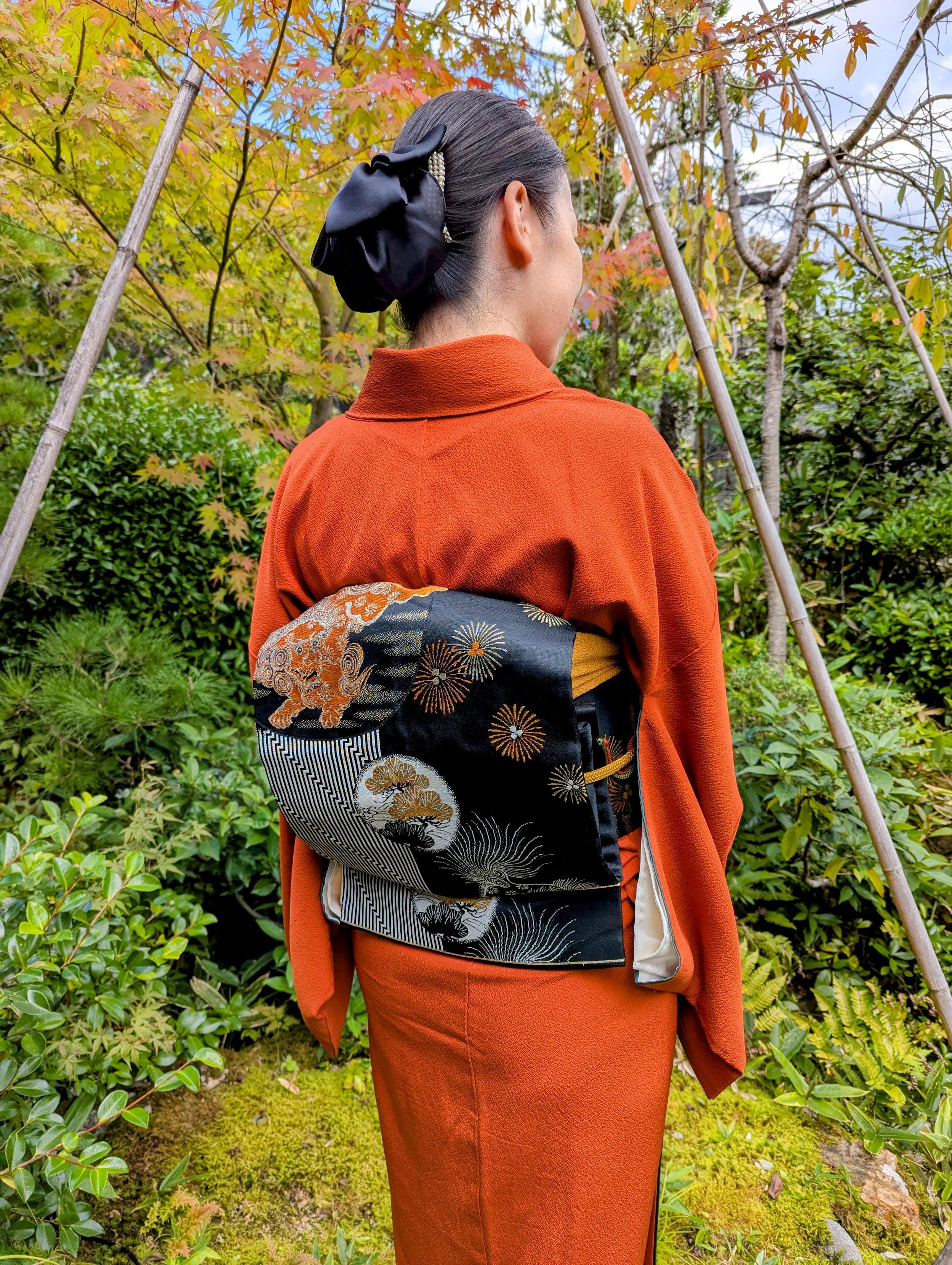 Atsuko-san dressed in an orange kimono and black obi, a nod to the Jack-o'-lanterns found at this time of year.